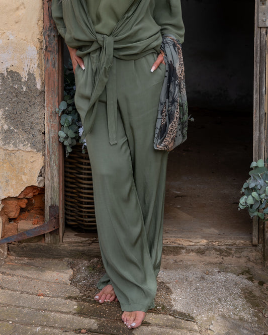These pants offer a super soft and cool feel against your skin, perfect for warm days or lounging in style. The wide-leg design ensures a flattering silhouette, while the elasticated waistband provides a comfortable fit that moves with you. A decorative drawstring bow adds a touch of charm and versatility, making these pants as stylish as they are practical. Whether you're dressing up for an evening out or keeping it casual, these pants are your go-to for easy elegance