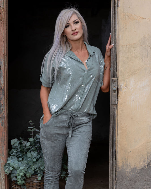 This top features a striking silver foil front panel that adds a touch of shimmer, making it a standout piece for any occasion. The longer length back panel provides extra coverage, ensuring a flattering fit from every angle. Designed with a beautifully framed collar, this top offers a polished, sophisticated look. The 3/4 sleeves come with a convenient pull-up tab, allowing you to adjust your style with ease. Whether you're dressing up for an event or keeping it casual, this versatile top combines comfort 